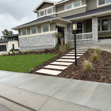 Frontscape green lawn stone pathway brown mulch